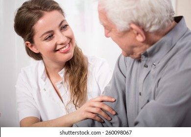 Picture of smiling nurse assisting senior man