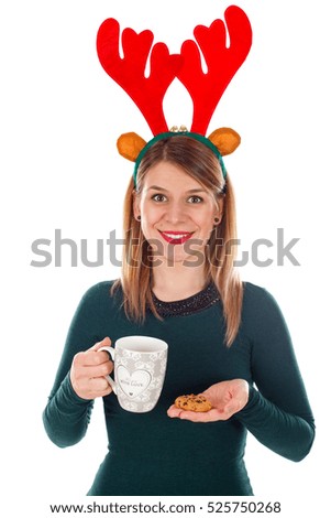 Picture of a smiling young woman with raindeer slide holding a cup of tea and a cookie