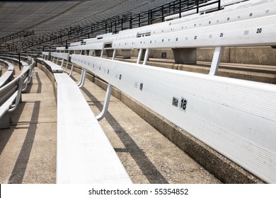 A Picture Of Some Empty Bleacher Seating In Rows, Taken In A Modern School Sports Stadium Facility.