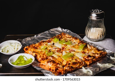 Picture Of A Square Frozen Pizza Cooked With Mozzarella Cheese Shaker And Peppers.