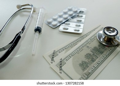 A Picture Of Stethoscope, Injection Syringe, Medicines And Fake Money For Medical Concept.