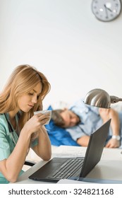 Picture Of Tired Nurse Drinking Coffee During Night Shift