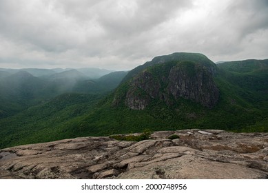Picture from the top of Grands-Jardins National park from the rocky surface overlooking the rolling mountains under a cloudy grey sky