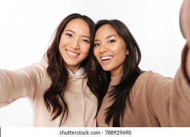 Picture of two asian happy positive ladies sisters make selfie looking camera.