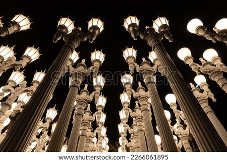 A picture of Urban Light, a public art designed by Chris Burden and unveiled in 2008, next to the Los Angeles County Museum of Art, at night.