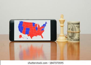 A Picture Of  US Election Map On Smart Phone With White King Chess And Fake Dollar Insight. People Are Waiting The Outcome Of US President 2020 Election.