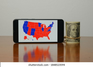 A Picture Of  US Election Map On Smart Phone And Fake Dollar Insight. People Are Waiting The Outcome Of US President 2020 Election.