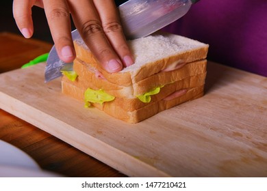 The picture is using a knife to divide the data. Large sandwiches stacked with ham salad.