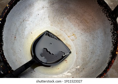 Picture Of Vegetable Oil Used To Fry Food Or Cook Food In A Steel Pan With A Black Spatula Placed On A Pan In Old Used Vegetable Oil. 