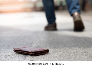 Picture of a wallet falling on the sidewalk