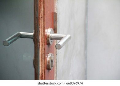  Picture of wet stainless handle on wooden frame with tinted glass and metal door handle.Self isolated or locked down or stay at home,quarantine during Covid-19 out break.