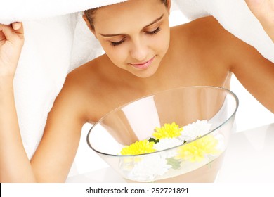 A picture of a woman doing facial treatment in spa
