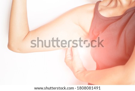 Picture of woman gesture showing back muscles, under arms, with fat under the skin.