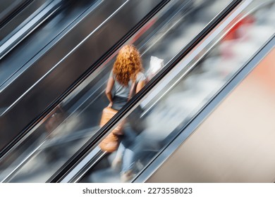 picture of a woman on an escalator with motion blur effect - Shutterstock ID 2273558023