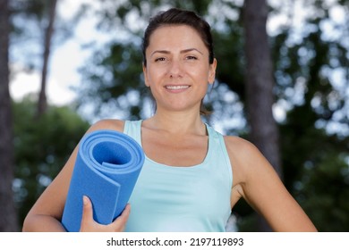 Picture Of Yoga Outdoor Instructor Holding Mat