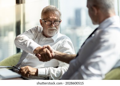 Picture of young business man taking to his older business partner. They are in white shirt and black tie. They are in a hotel lobby.  - Powered by Shutterstock