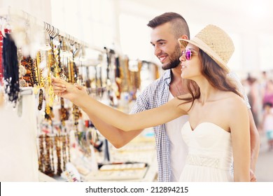 A Picture Of A Young Couple Buying Souvenirs