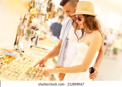 A Picture Of A Young Couple Buying Souvenirs