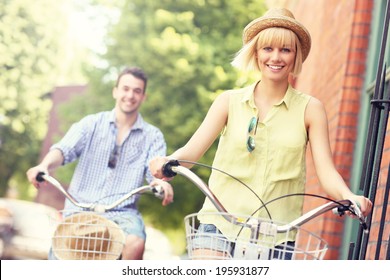 A picture of a young couple cycling in the city