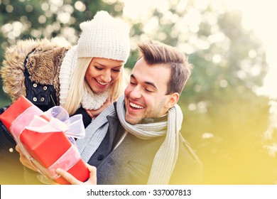 A Picture Of A Young Couple With A Present In The Park