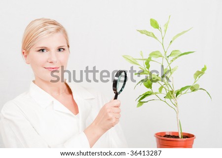 Picture of a young happy female scientist botanic and a green plant