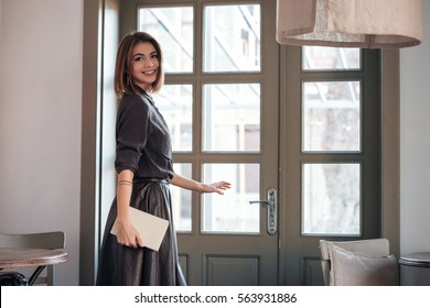 Picture Of Young Incredible Cute Lady Open The Door In Cafe And Holding Book.