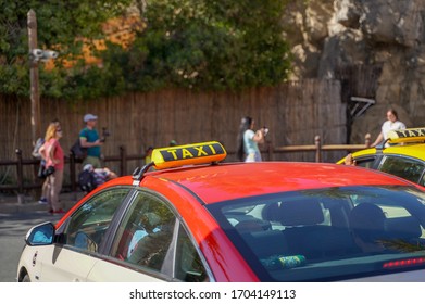 Picture of young man in cap and plaid shirt sitting in back seat in yellow taxi. Happy male getting into a cab. Businessman entering a taxi on city street - Powered by Shutterstock