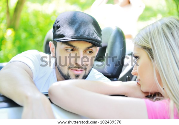 Picture of a\
young man in a car talking to a\
girl