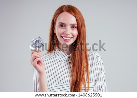 picture of young redhead be lost in thought businesswoman in striped shirt with pack of condom and birth choosing thinking white background studio