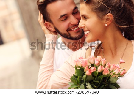 A picture of a young romantic couple with flowers in the city