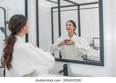 Ein Bild einer jungen Frau in einem Bademantel im Badezimmer