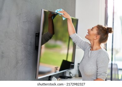 Picture Of Young Woman Cleaning Tv Screen