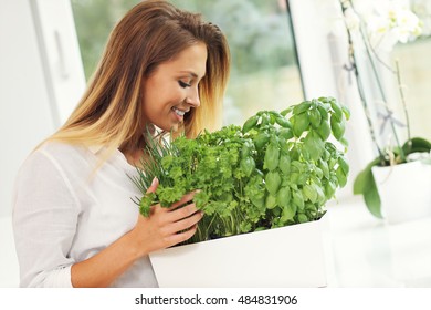 Picture Of Young Woman With Herbs In The Kitchen