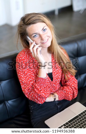 Similar – Entrepreneur woman wearing red shirt working with a laptop sitting on a couch at home