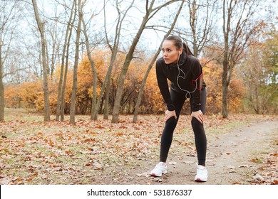 Picture Of Young Woman Runner In Warm Clothes And Earphones Running In Autumn Park