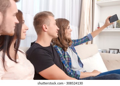 Pictures for memories. Pleasant upbeat friends sitting on the couch and making selfie while having fun. - Shutterstock ID 308524130