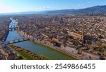 A picturesque aerial view of Florence, showcasing the Arno River, multiple historic bridges, and stunning Tuscan cityscape