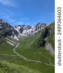 Picturesque Alpine panorama with white snow-capped peaks while hiking in Mont Blanc Massif on a sunny day in Val Ferret on the way to Lacs de Fenêtre Lakes