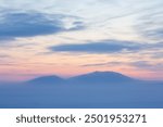 Picturesque arctic landscape. View of the snow-capped mountains at sunset. Cold winter weather. Frosty fog over the tundra. Winter arctic nature. Mount Dionysius, Chukotka, Siberia, Far North Russia.