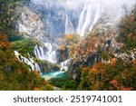 Picturesque autumn waterfall in a calm forest environment in rainy, foggy autumn weather in Plitvice lakes