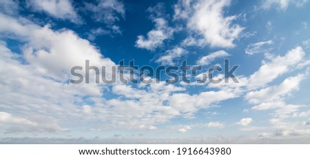Picturesque azure blue sky with fibratus and cumulus clouds. Beautiful nature background.