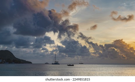 Picturesque clouds float in the evening sky, illuminated with golden and pink. Silhouettes of boats and yachts are visible on the surface of the calm ocean. Seychelles. Mahe. Beau Vallon - Shutterstock ID 2249851815