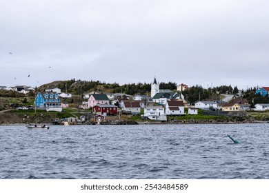 A picturesque coastal Newfoundland town viewed from the ocean, with its charming harbor, rocky shoreline, and maritime landscape blending seamlessly into the horizon. - Powered by Shutterstock