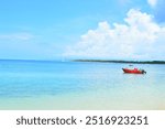 A picturesque coastal view showcasing the beauty of a tropical paradise, with a vibrant red boat adding a pop of color to the serene landscape.