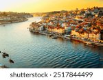 Picturesque, colorful view at old town Porto at sunset, Portugal with bridge Ponte Dom Luis over Douro river. Oporto, touristic mediterranean city