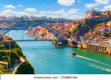 Picturesque, colorful view at old town Porto, Portugal with bridge Ponte Dom Luis over Douro river. Oporto, touristic mediterranean city of culture, architecture, wine, sport and gastronomy.