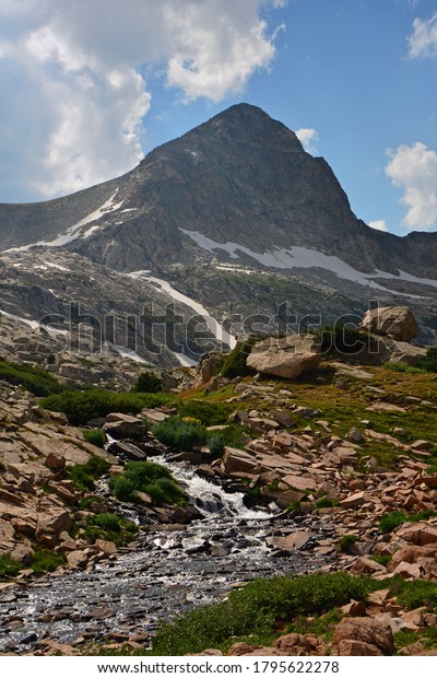 picturesque creek and waterfall and\
mount toll on a summer day along the hiking trail to blue lake in\
the indian peaks wilderness area, near nederland, colorado\
