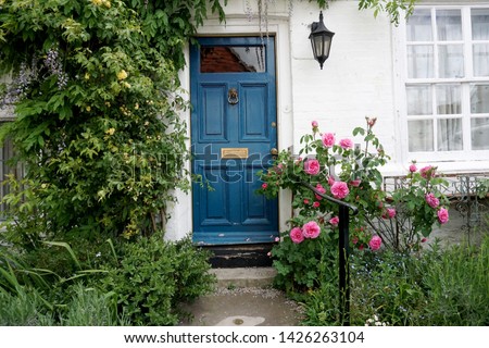 Picturesque facade doorway with beautiful flowers in front