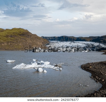 Sólheimajökull picturesque glacier in southern Iceland. The tongue of this glacier slides from the volcano Katla. Beautiful glacial lake lagoon with blocks of ice and surrounding mountains.