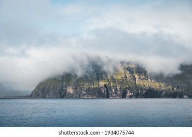 Picturesque green cliffs on Litla Dimun island and atlantic ocean in Faroe islands.